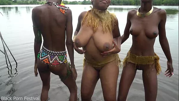 Raw documentary footages with 3 African tribe girls dancing in the river in the forrest