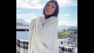 Linda amadora mostrando seios naturais na varanda ao ar livre