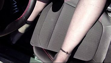 Füße von Nylonjunge in Strumpfhose im Auto